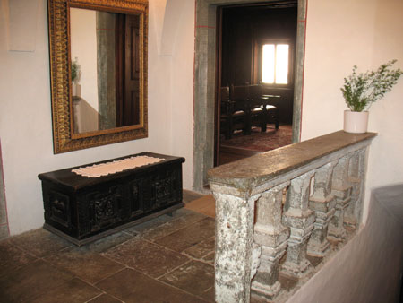 Veža v nadstropju s staro skrinjo in kamnito stebričasto ograjo;